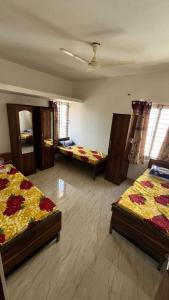 a large room with three beds in it at Krushna Boys Pg in Ahmedabad