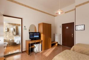 リヴォルノにあるParking Hotel Giardinoのテレビ、バスルームが備わるホテルルームです。