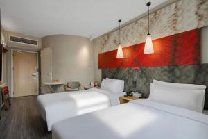 a hotel room with two beds and a table at Ibis Chengdu Kehua Hotel in Chengdu +257 photos