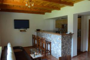 cocina con barra y TV en la pared en Dolinka Holiday Home, en Levoča