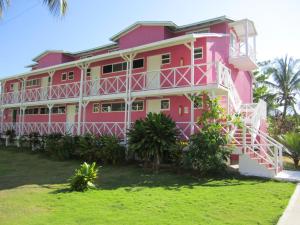 uma casa cor-de-rosa com acabamento branco em Sitio exclusivo y tranquilo em San Andrés