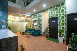 a living room with a blue couch and a door at Hotel Square Plaza At Airport in New Delhi