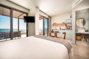 a bedroom with a bed and a view of the ocean at NOA BEACHFRONT SUITES in Kardamaina