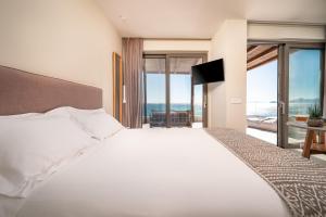 Ένα ή περισσότερα κρεβάτια σε δωμάτιο στο NOA BEACHFRONT SUITES