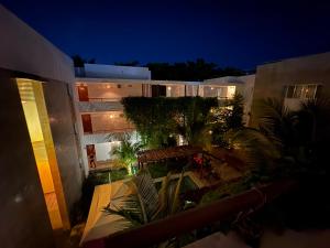 an apartment building at night with trees and plants at Hotel Suites Reyvaj in Mérida
