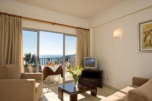 a living room with a couch and a table with flowers at Silmar in Albufeira