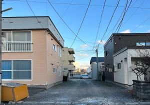 eine Gasse zwischen zwei Gebäuden mit einem daneben geparkt in der Unterkunft Ota Apartment - Vacation STAY 16058 in Otaru