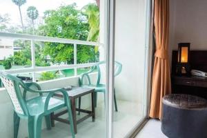 a room with a table and chairs and a window at The Nice Patong Hotel in Patong Beach