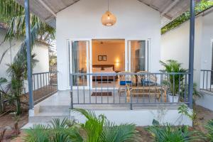 a porch of a house with a table and chairs at Agonda Brown Sand in Agonda