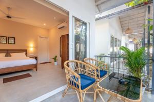 una camera da letto con un letto e un tavolo di vetro di Agonda Brown Sand ad Agonda