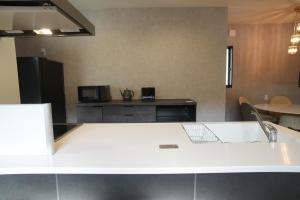 una cucina con bancone bianco e lavandino di Awaji Play Resort a Minamiawaji Altre 25 foto