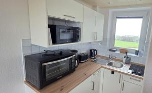 a kitchen with a microwave and a sink at Tief 10 Austernfischer 708 in Wangerland