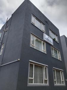 ein schwarzes Gebäude mit weißen Fenstern an der Seite in der Unterkunft Frere Hill Guesthouse in Durban
