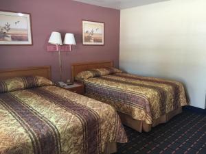 a hotel room with two beds and a lamp at Best Value Inn Motel Sandusky in Marianna