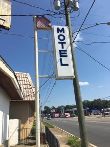 una señal en un poste frente a una tienda en Best Value Inn Motel Sandusky, en Marianna