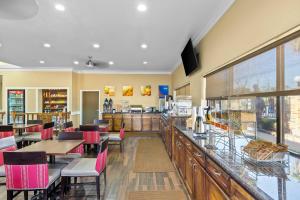 ein Restaurant mit einer Bar mit Tischen und Stühlen in der Unterkunft Comfort Suites Lake Jackson Clute in Lake Jackson