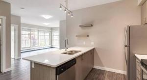 a white kitchen with a sink and a refrigerator at Mdx in Edmonton