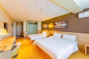 a hotel room with two beds and a desk at IU Hotel Tianjin Tianta Scenic Spot Wujiayao Metro Station in Tianjin +196 photos
