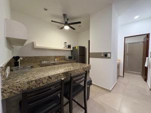 a kitchen with a counter and a ceiling fan at Hotel Suites Reyvaj in Mérida
