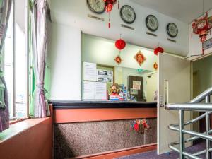 a restaurant with clocks on the wall and a counter at Meriton Hotel in Singapore