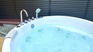 a jacuzzi bath tub with a faucet at Solana富士御殿場 in Gotemba