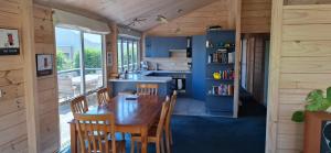 een keuken en eetkamer met een houten tafel en stoelen bij A Waihi Beach Getaway in Waihi Beach +10 foto's