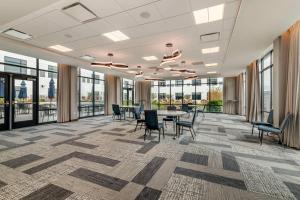 an office lobby with a table and chairs and windows at Cambria Hotel Portland Downtown Old Port in Portland