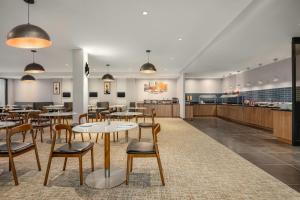 ein Restaurant mit Tischen und Stühlen und eine Cafeteria in der Unterkunft Radisson Hotel Montreal Airport in Saint-Laurent