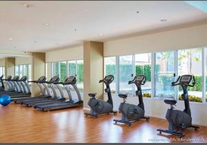 a gym with a row of treadmills and ellipticals at Lumpini nawamin in Ban Bang Toei (1)