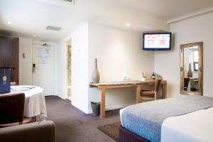 
a hotel room with a television and a bed at Hotel Richmond on Rundle Mall in Adelaide
