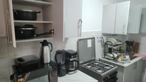 a kitchen with white cabinets and a coffee maker at Naivasha Naivegas C5 Staycation by Charlie izzy in Munyu