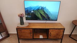 a tv sitting on top of a table with a vase of flowers at Naivasha Naivegas C5 Staycation by Charlie izzy in Munyu