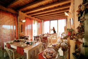 a room with tables and a woman standing in the window at Agriturismo Monte degli Aromi in Villaga +69 photos