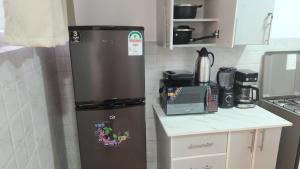 a small kitchen with a refrigerator and a microwave at Naivasha Naivegas C5 Staycation by Charlie izzy in Munyu