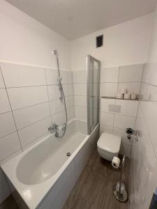 Altstadtperle Ettlingen mit Smart TV und WLAN في إيتلينغن: حمام أبيض مع حوض ومرحاض