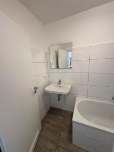 Altstadtperle Ettlingen mit Smart TV und WLAN في إيتلينغن: حمام أبيض مع حوض وحوض استحمام