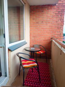 2 Stühle und ein Tisch vor einer Ziegelwand in der Unterkunft BuTaS TaUrAgEje in Tauragė