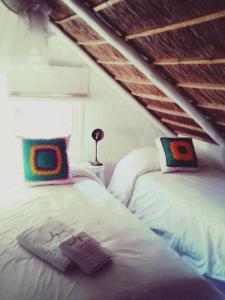 dos camas sentadas una al lado de la otra en una habitación en Posada Valizas, en Barra de Valizas