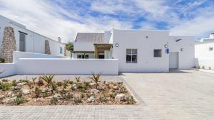 a white house with a courtyard in front of it at Skobbejak in Paternoster