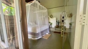 a bedroom with a bed and a glass shower at Calma Cafe - Surf, Stay and Yoga in Dickwella