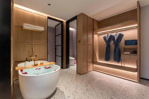 ein Badezimmer mit Badewanne und Waschbecken in der Unterkunft Changzhou Railway Station Qingguoxiang Manxin Hotel in Changzhou + 16 Fotos