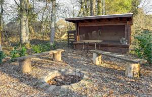 Un refugio para picnic con dos bancos y una parrilla. en 3 Bedroom Beautiful Home In Silkeborg, en Abildskov