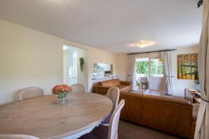 a living room with a table and a couch at 1 Mustique River Club in Plettenberg Bay