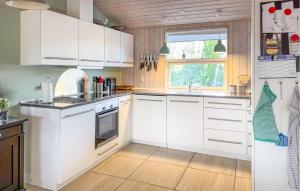 Una cocina con gabinetes blancos y un refrigerador. en 3 Bedroom Beautiful Home In Silkeborg, en Abildskov