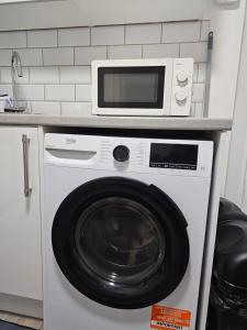 a microwave sitting on top of a washing machine at Entire Flat in heart of Oxford in Oxford