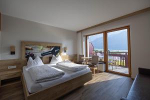 Un dormitorio con una cama grande y un balcón. en Residence Egger, en Terlano
