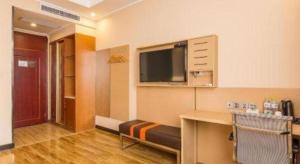 a room with a desk and a flat screen tv at 7 Days Premium·Hotel Pei County Longcheng International in Datun
