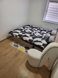 a bedroom with a bed and a chair and a rug at Apartman Magi in Prnjavor