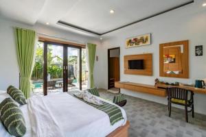 ein Schlafzimmer mit einem großen Bett und einem Fernseher in der Unterkunft Villa Rama Penida by ABM in Toyapakeh