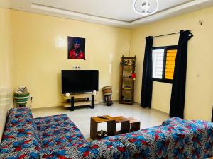 Chambre avec salle de bain privée في مبور: غرفة معيشة مع أريكة وتلفزيون بشاشة مسطحة